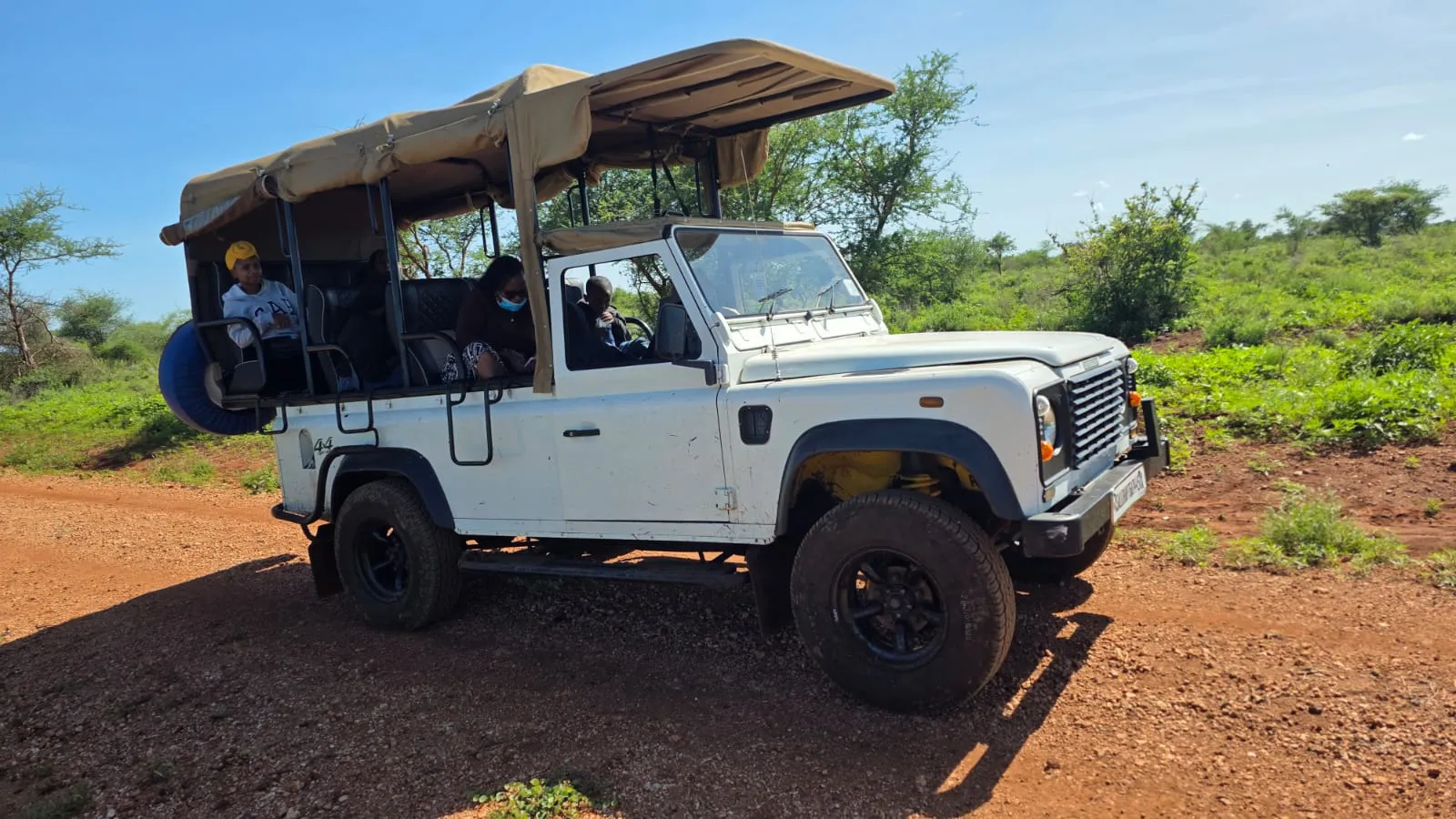 Hot air balloon floating over Maasai Mara at sunrise with wildlife below